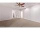 Large bedroom with ceiling fan, plush carpets, and access to the ensuite bathroom and walk-in closet at 9730 W Gulf Hills Dr, Sun City, AZ 85351
