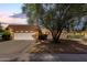 Charming single-story brick home with a two-car garage and mature landscaping at dusk at 9730 W Gulf Hills Dr, Sun City, AZ 85351
