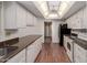 Well-lit kitchen boasts a ceiling fan, white appliances, cabinetry, and warm wood-look flooring at 9730 W Gulf Hills Dr, Sun City, AZ 85351