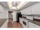 Well-lit kitchen featuring white appliances, cabinetry, and warm wood-look flooring at 9730 W Gulf Hills Dr, Sun City, AZ 85351