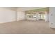 An open living room boasts neutral colors and a seamless transition to the outdoor lanai at 9730 W Gulf Hills Dr, Sun City, AZ 85351