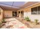 A charming patio area featuring custom stonework, mature plantings, and a covered awning at 9730 W Gulf Hills Dr, Sun City, AZ 85351