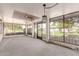 Sunroom featuring screened windows, ceiling fan, and an outdoor view of the beautifully landscaped yard at 9730 W Gulf Hills Dr, Sun City, AZ 85351
