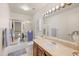 Bright bathroom with a vanity, a framed mirror, a toilet, and a shower-tub combination with sliding glass doors at 1005 W Berridge Ln, Phoenix, AZ 85013