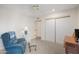 Cozy bedroom featuring a comfy recliner, soft carpet, a ceiling fan, and a closet with sliding doors at 1005 W Berridge Ln, Phoenix, AZ 85013