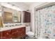 Bathroom featuring a vanity, mirror, cabinet, and a shower with floral curtain at 10510 W Palmeras Dr, Sun City, AZ 85373