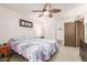 Bedroom featuring a ceiling fan, a queen-size bed with a patterned quilt, and carpeted floors at 10510 W Palmeras Dr, Sun City, AZ 85373