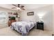 Well-lit bedroom with a ceiling fan, dresser, TV, and framed photos above the bed at 10510 W Palmeras Dr, Sun City, AZ 85373