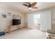 Bright living room with large windows, a TV, and neutral carpeting, and a ceiling fan at 10510 W Palmeras Dr, Sun City, AZ 85373