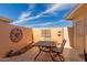 Outdoor patio area with a metal table, chairs, and decor with a clear blue sky background at 10510 W Palmeras Dr, Sun City, AZ 85373