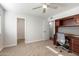 Bedroom with neutral carpet, ceiling fan, walk-in closet and wooden desk with cabinets and drawers at 10924 W Santa Fe Dr, Sun City, AZ 85351