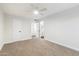 Bright bedroom featuring neutral carpet, white walls, ceiling fan, ensuite bathroom, and closet for ample storage at 10924 W Santa Fe Dr, Sun City, AZ 85351