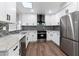 Modern kitchen featuring sleek white cabinetry, stainless steel appliances, and a skylight at 10924 W Santa Fe Dr, Sun City, AZ 85351