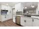 Modern kitchen with stainless steel appliances, white cabinets, and a mosaic backsplash at 10924 W Santa Fe Dr, Sun City, AZ 85351