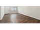 Bright living room featuring stylish wood floors, a large window, and a white front door at 10924 W Santa Fe Dr, Sun City, AZ 85351