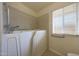 Bathroom featuring a walk-in tub, tile backsplash, and window for natural light at 11067 W White Mountain Rd, Sun City, AZ 85351