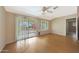 Bright bedroom with wood floors, ceiling fan, and large glass sliding doors to the outside at 11067 W White Mountain Rd, Sun City, AZ 85351