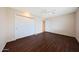 A bright bedroom features wood floors, closet and ceiling fan at 11067 W White Mountain Rd, Sun City, AZ 85351