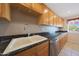 Traditional kitchen with light wood cabinetry, granite countertops, and a double bowl sink at 11067 W White Mountain Rd, Sun City, AZ 85351