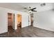 Spacious main bedroom featuring a ceiling fan, wood-look flooring and attached walk-in closet and bathroom at 11229 E Emelita Ave, Mesa, AZ 85208