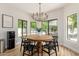 Inviting dining room features a round wooden table, black chairs, and backyard views at 1152 W Sunrise Pl, Chandler, AZ 85248