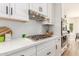 Bright kitchen features white cabinets, subway tile backsplash, and stainless steel gas cooktop at 1152 W Sunrise Pl, Chandler, AZ 85248