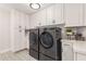 Laundry room with modern washer and dryer, built-in white cabinets, and stylish tile flooring at 1152 W Sunrise Pl, Chandler, AZ 85248