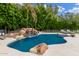 Beautiful pool featuring a rock waterfall, lush landscaping, and relaxing lounge chairs at 1152 W Sunrise Pl, Chandler, AZ 85248