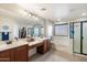 Large bathroom with double sink vanity, separate shower and tub, large mirror, and walk-in closet access at 12132 W Daley Ln, Sun City, AZ 85373