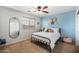 Bright bedroom with a full bed, neutral carpet, ceiling fan, and woven wall decor at 12132 W Daley Ln, Sun City, AZ 85373