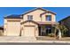 Inviting two-story home boasts a three-car garage, desert landscaping, and solar panels for energy efficiency at 12132 W Daley Ln, Sun City, AZ 85373