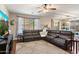 Cozy living room with an extra large sectional sofa, ceiling fan and large window at 12132 W Daley Ln, Sun City, AZ 85373