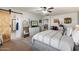 Light-filled main bedroom featuring ensuite bath, ceiling fan, dresser with tv, and calming decor at 12132 W Daley Ln, Sun City, AZ 85373