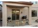 Covered patio area with sliding glass doors, a grill, and chairs for outdoor relaxation at 12132 W Daley Ln, Sun City, AZ 85373