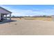 This expansive backyard offers ample space for outdoor activities, featuring gravel and a backdrop of clear blue skies at 12204 W Blackhawk Rd, Casa Grande, AZ 85194