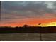 Backyard block fence view with colorful sunset and a distant mountain view at 12204 W Blackhawk Rd, Casa Grande, AZ 85194