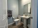 Half bathroom with a white pedestal sink, toilet, and decorative towels at 12204 W Black Hawk Rd, Casa Grande, AZ 85194