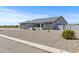 A well maintained property with desert landscaping, showcasing the house's stone accents and concrete driveway at 12204 W Black Hawk Rd, Casa Grande, AZ 85194