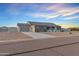 This house is clad with stone and has a three-car garage and desert landscaping at 12204 W Black Hawk Rd, Casa Grande, AZ 85194