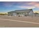 Charming exterior view of a single-story home at sunset featuring stone accents and desert landscaping at 12204 W Black Hawk Rd, Casa Grande, AZ 85194