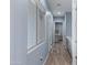 Bright hallway with light-colored wood floors, white trim, and a view into the laundry room at 12204 W Black Hawk Rd, Casa Grande, AZ 85194