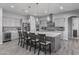 This kitchen includes a large island with pendant lighting, stainless steel appliances, and gray cabinetry at 12204 W Black Hawk Rd, Casa Grande, AZ 85194