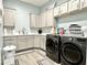 Well-organized laundry room with modern washer and dryer, ample cabinetry and sink, plus stylish floor mats at 12204 W Blackhawk Rd, Casa Grande, AZ 85194