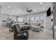 Spacious living room with ceiling fan, neutral sectional, and stone accent wall, open to kitchen at 12204 W Blackhawk Rd, Casa Grande, AZ 85194