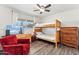 Inviting bedroom with bunk beds, wood-look flooring, and a red cushioned chair at 13202 N 22Nd Ave, Phoenix, AZ 85029