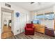 Well-lit bedroom showcasing wood-look floors, ample closet space, and a red cushioned chair at 13202 N 22Nd Ave, Phoenix, AZ 85029