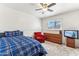 Bright bedroom featuring a plaid comforter, ceiling fan, and a comfortable reading chair at 13202 N 22Nd Ave, Phoenix, AZ 85029