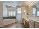 Bright bathroom featuring double vanities, a tiled glass shower, and a luxurious soaking tub at 13236 N 13Th St, Phoenix, AZ 85022