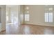 Spacious living room featuring wood floors, tall windows with shutters, and a seamless transition to other spaces at 13236 N 13Th St, Phoenix, AZ 85022