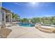 Backyard pool with rock accents, lush landscaping, and a clear blue sky, creating a serene outdoor oasis at 13236 N 13Th St, Phoenix, AZ 85022